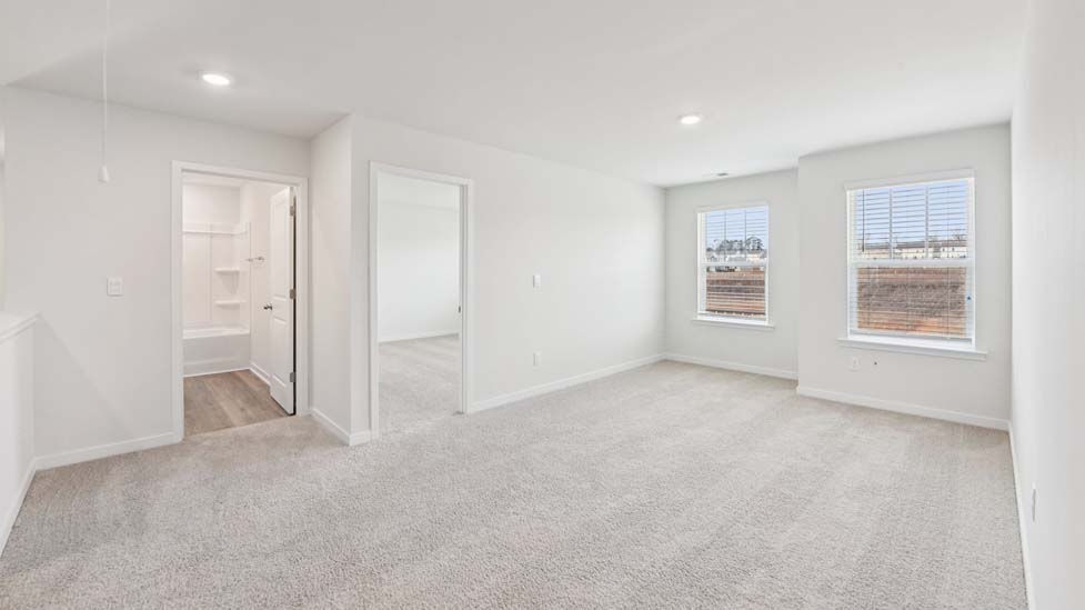 Carpeted bedroom with large windows
