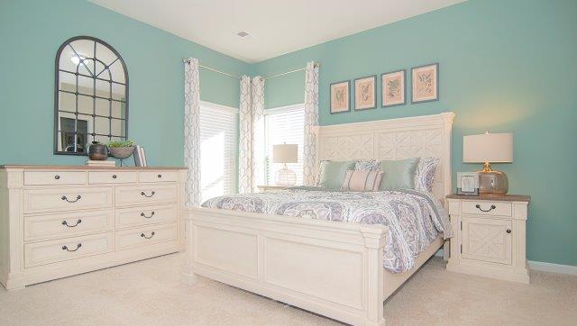 Carpeted bedroom with two small windows