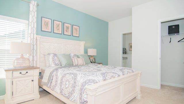 Carpeted bedroom with two small windows