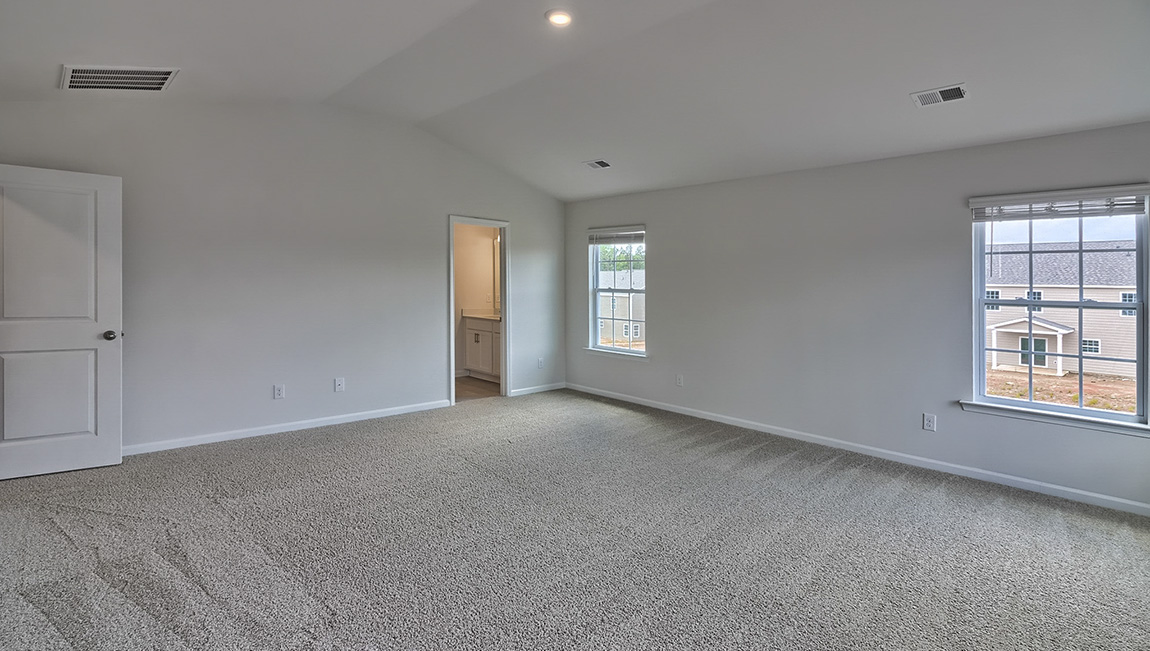 Primary carpeted bedroom  with 4 windows