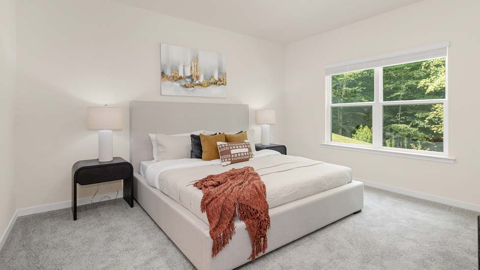 Carpeted primary bedroom with large window and ceiling fan. New Home in Charlotte, North Carolina