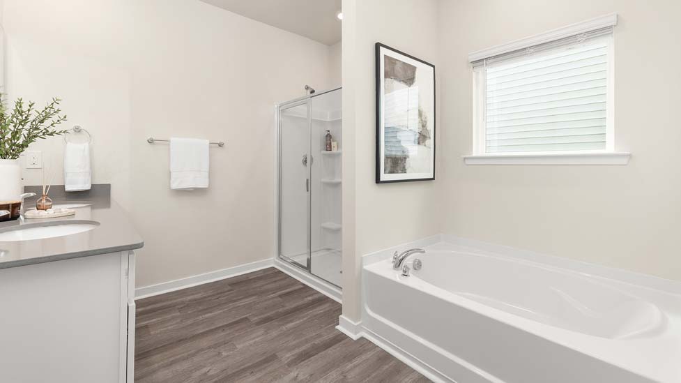 Primary Bathroom with white cabinets and counters, double vanity, and glass door shower. New Home in Charlotte, North Carolina