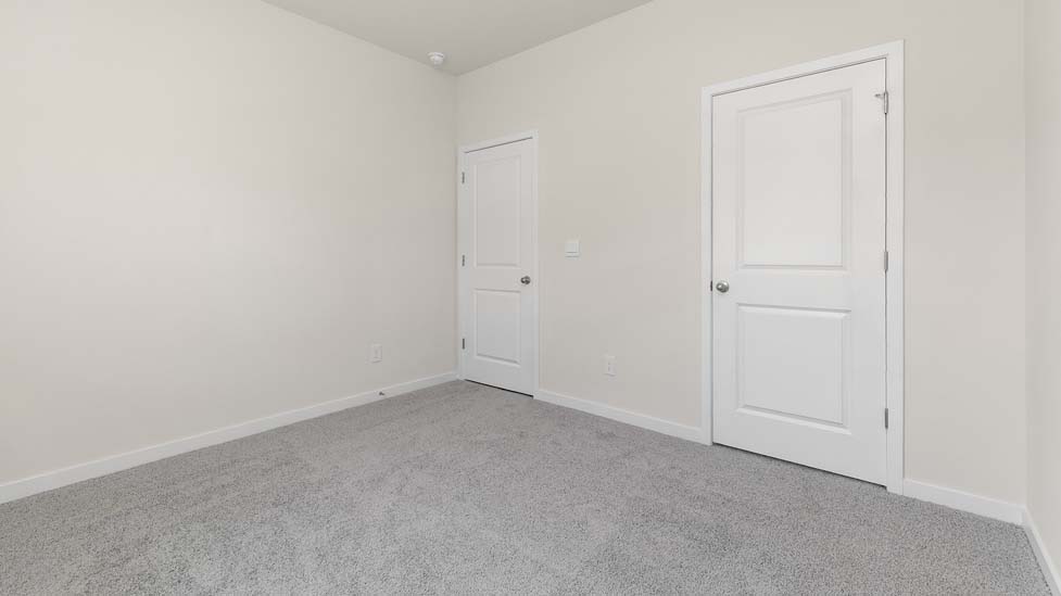 Carpeted bedroom with large window. New Home in Charlotte, North Carolina