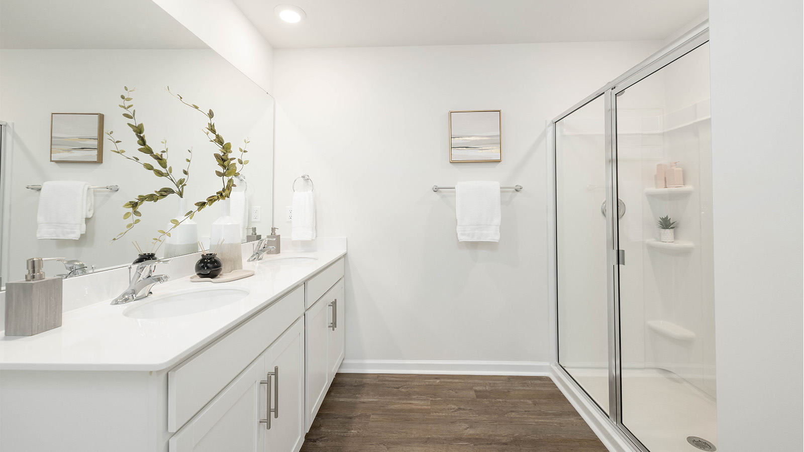 Primary bathroom with double sinks, white cabinets and counters