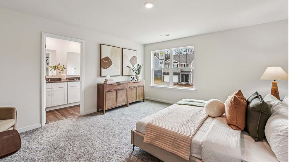 Primary carpeted bedroom with windows