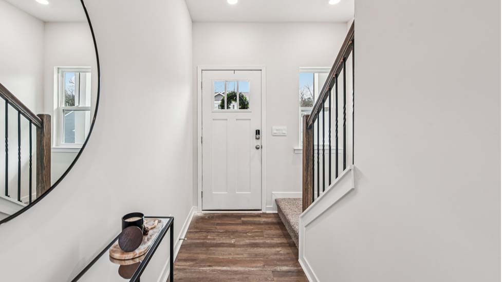 Welcoming foyer with wood floors, view of front door