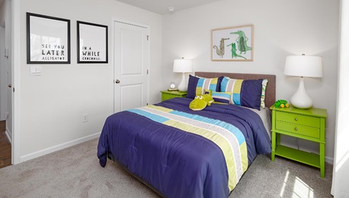 Carpeted bedroom with large window. New Home in Charlotte, North Carolina