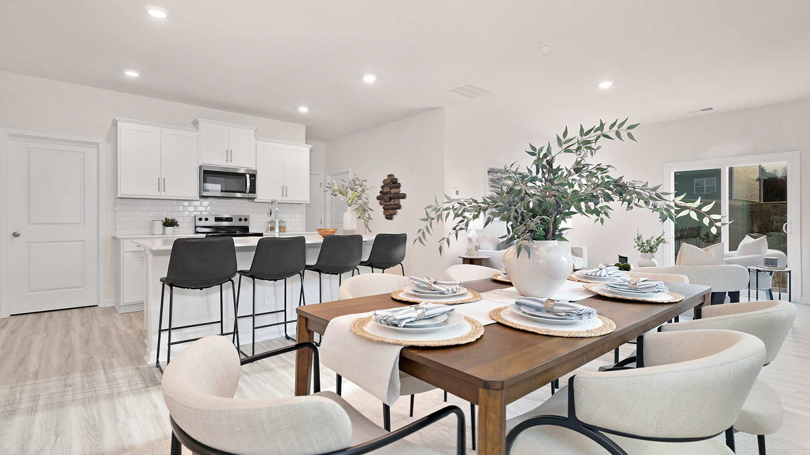 Kitchen and island with white cabinets, counters, subway tile backsplash and stainless steel appliances