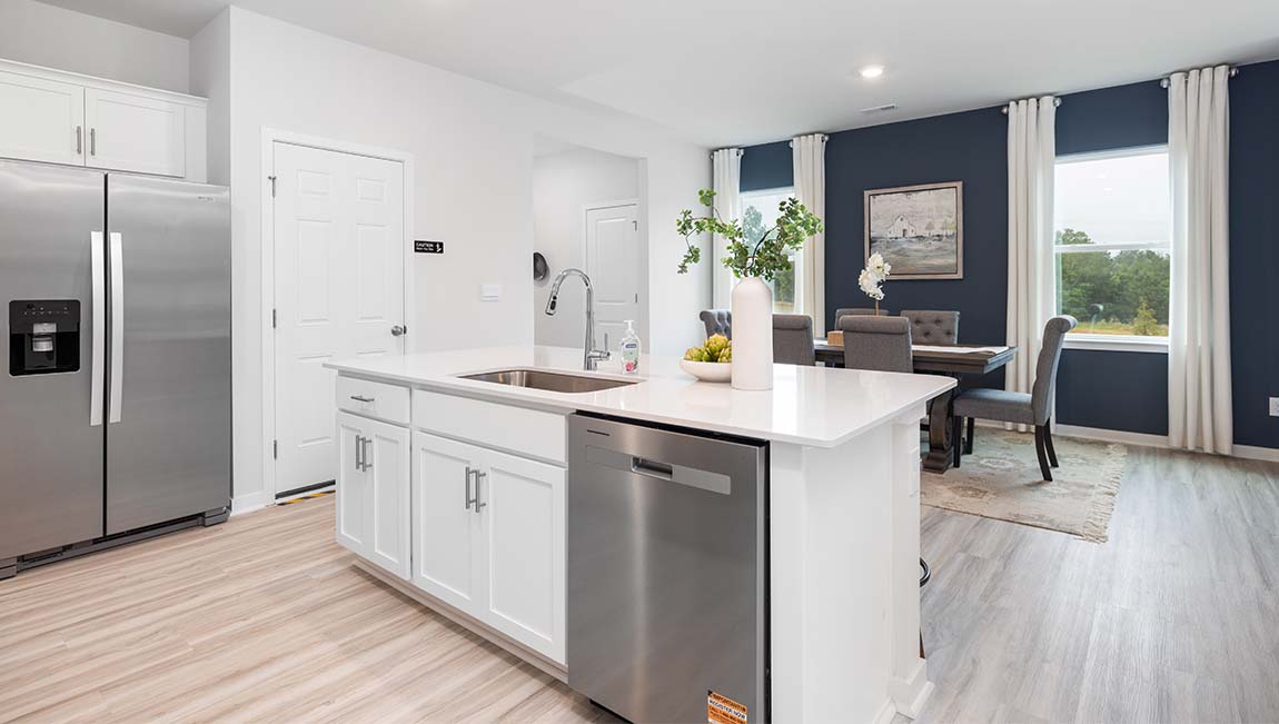 Kitchen and island with white cabinets and wood flooring