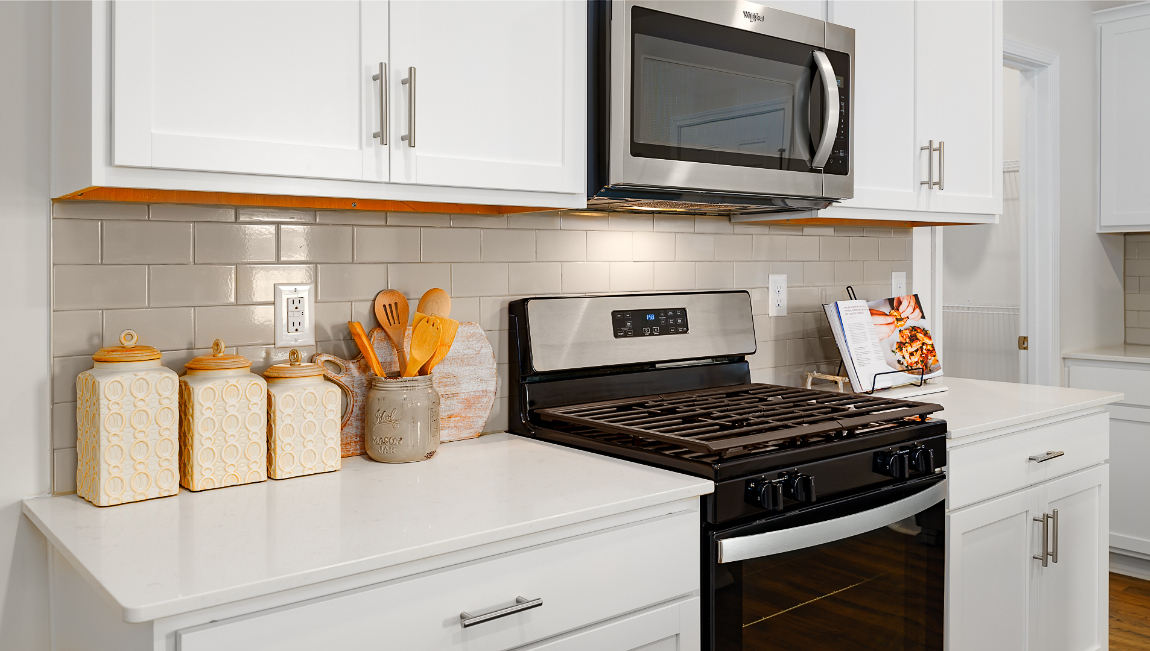Kitchen and island with white cabinets and wood flooring