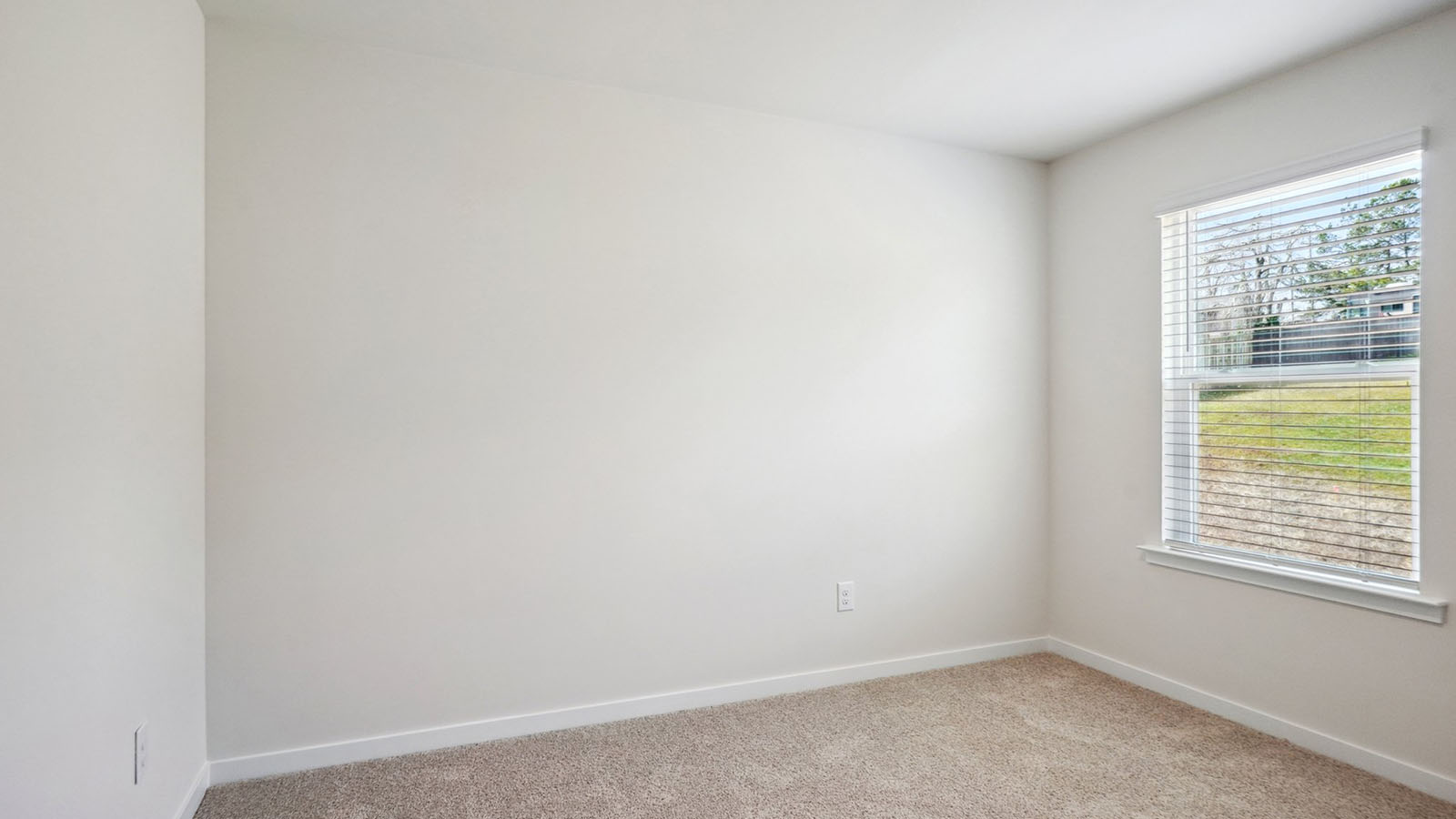 Model carpeted bedroom with small window