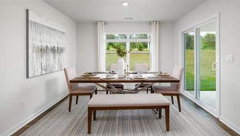 Dining area beside kitchen and living room with large windows and sliding glass back door. New Home in Charlotte, North Carolina