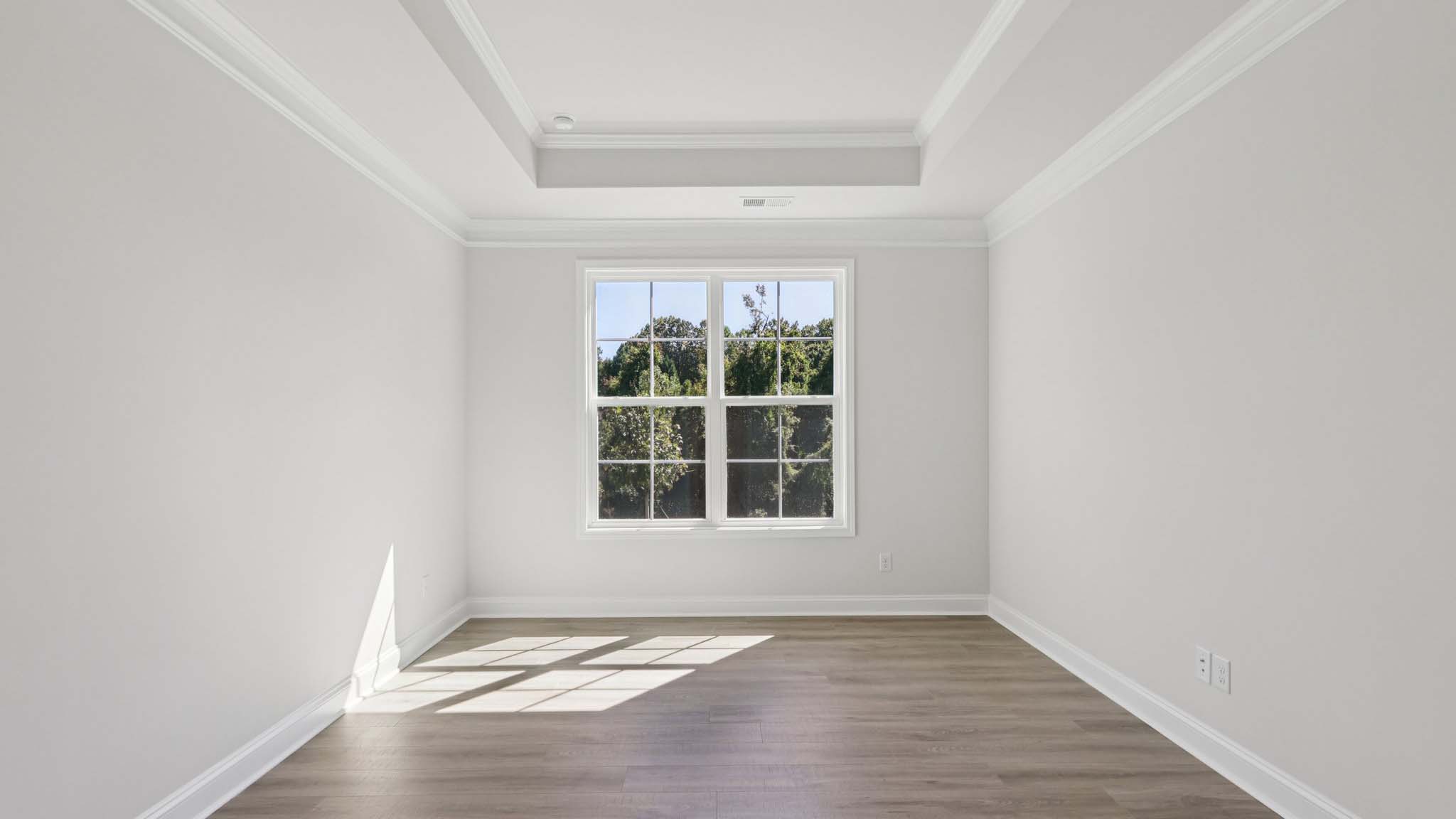 primary bedroom with vinyl flooring and large window