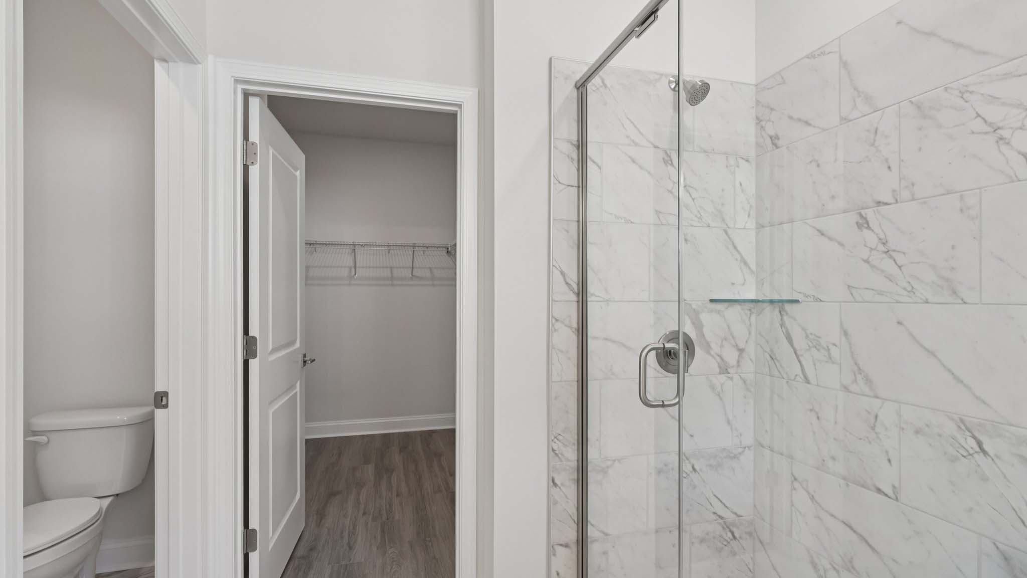 primary bathroom with double sink vanity and large glass shower and bathtub