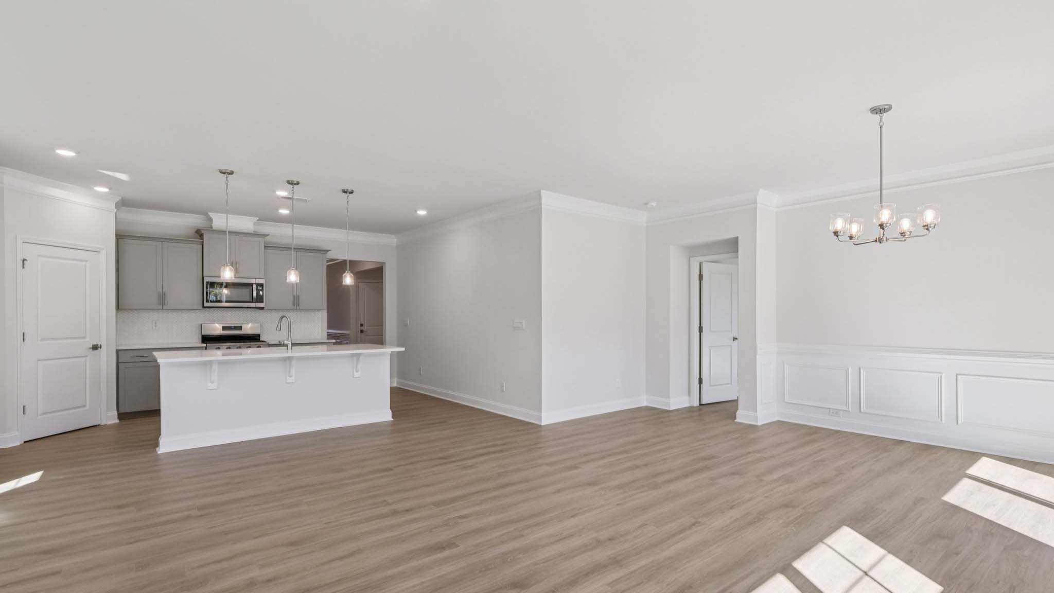 living room beside kitchen with large windows and fireplace