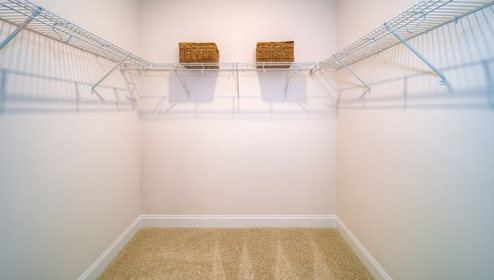 Primary walk in closet with carpet and hanger racks