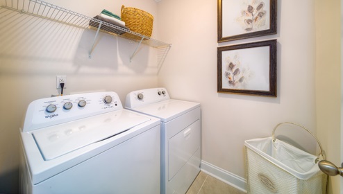 Laundry room with built in racks above machines