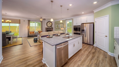 Kitchen and island with wood floors, white cabinets, and stainless steel appliances