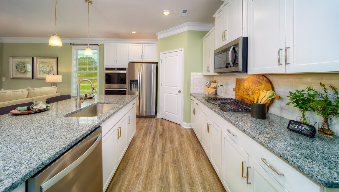 Kitchen and island with wood floors, white cabinets, and stainless steel appliances