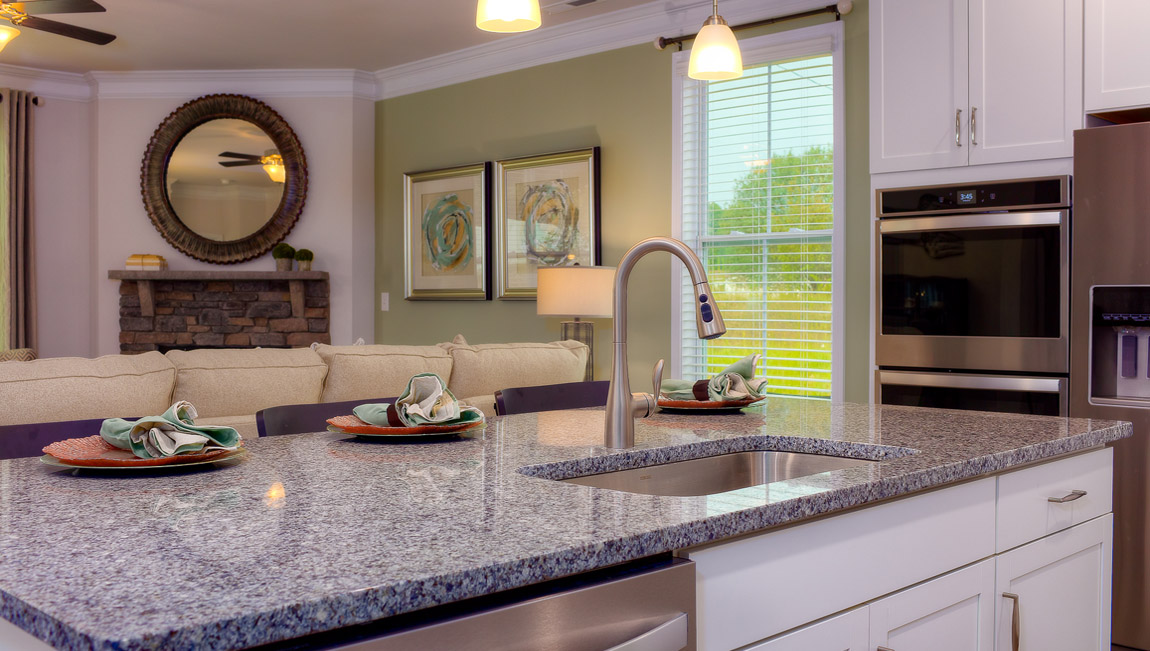 Kitchen and island with wood floors, white cabinets, and stainless steel appliances