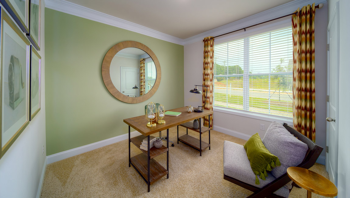 Carpeted bedroom with large window, used as an office