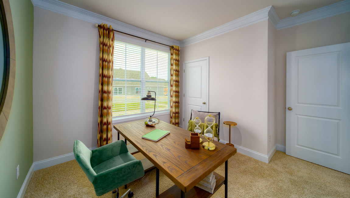 Carpeted bedroom with large window, used as an office