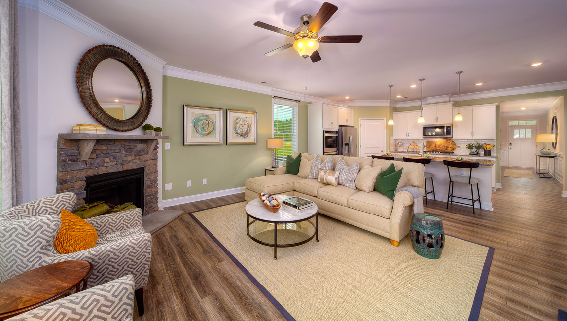 Open living room with wood floors, fireplace, and two large windows