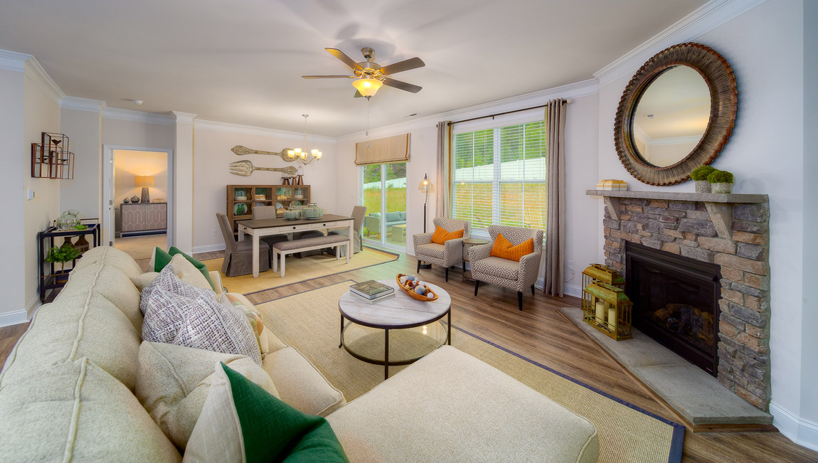Open living room with wood floors, fireplace, and two large windows