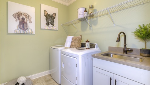 Laundry room with racks for storage and a sink with white cabinets