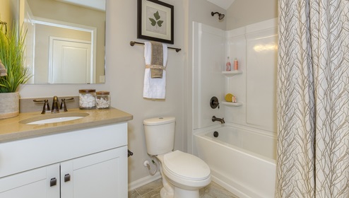 Bathroom with bathtub and white cabinets
