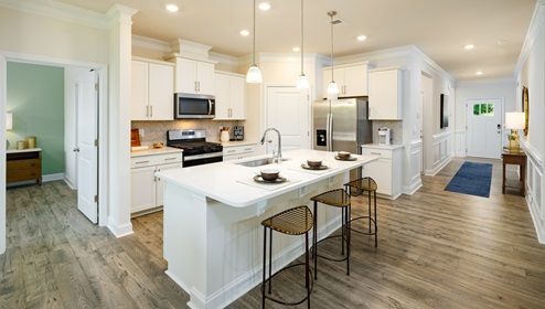 Kitchen and  island, white counters and cabinets, wood floors