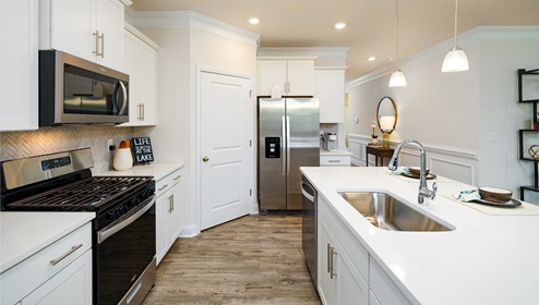 Kitchen and  island, white counters and cabinets, wood floors