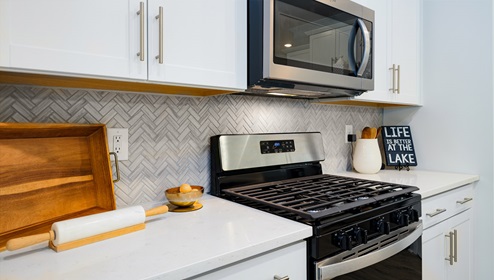 Kitchen and island, white counters and cabinets, wood floors