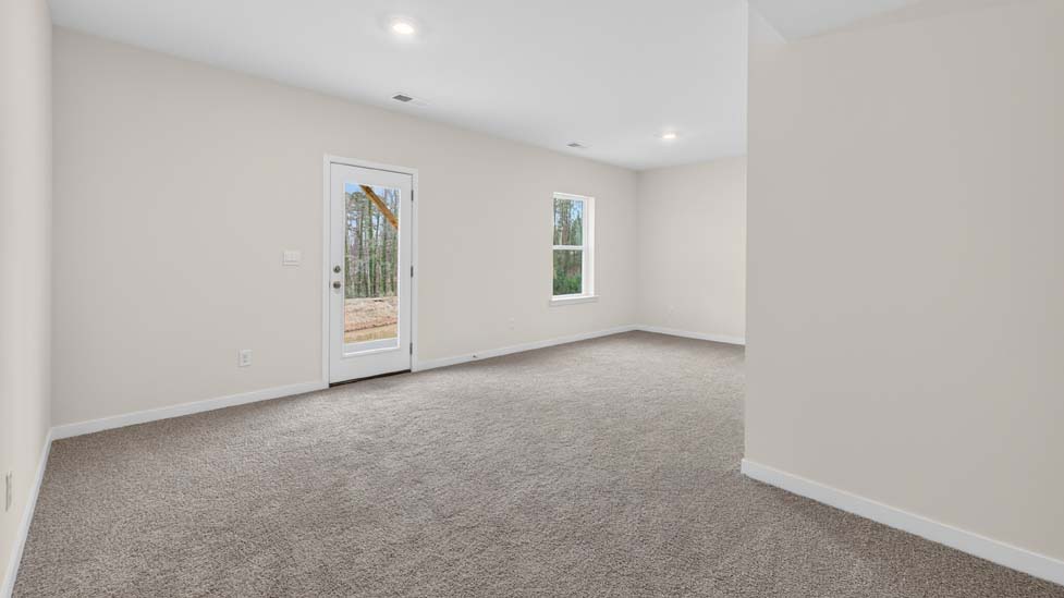 carpeted loft space with large windows