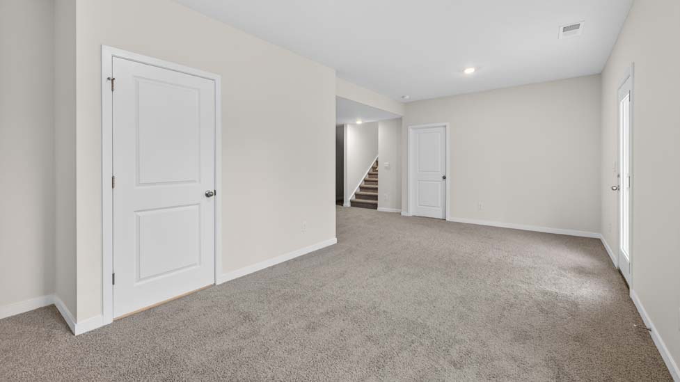 carpeted loft space with large windows