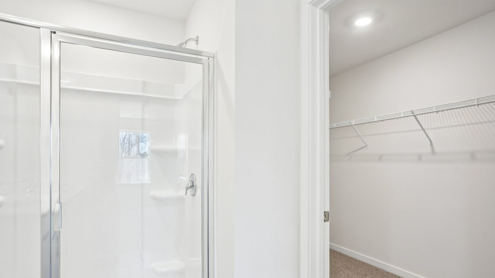 Bathroom with double sink vanity, standing glass door shower and connected walk in closet