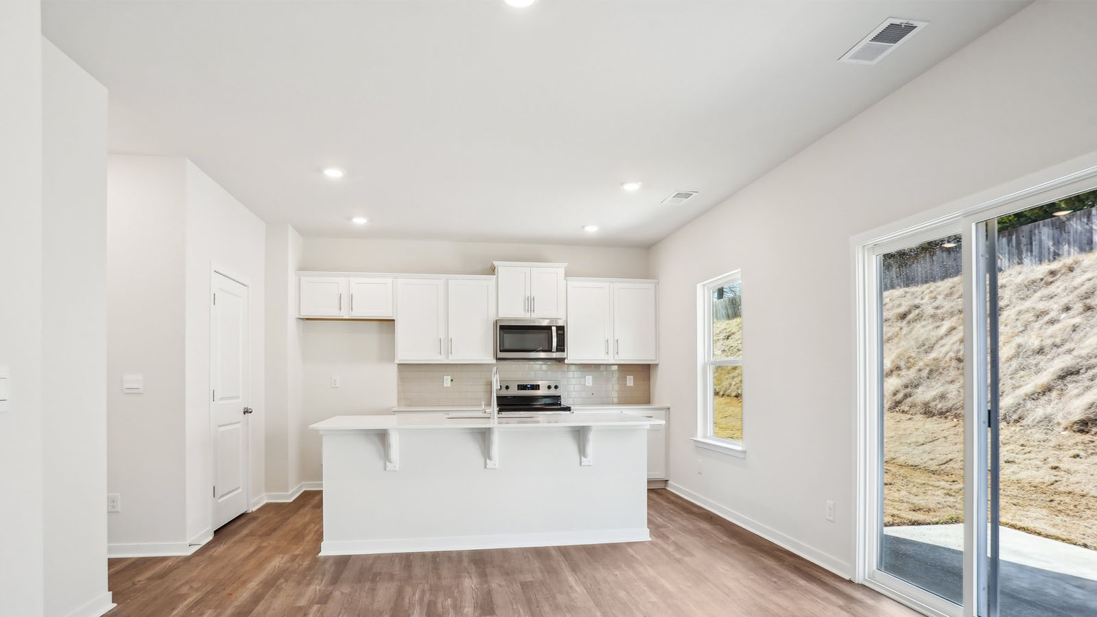 Kitchen and island with subway tile backsplash and stainless steel appliances