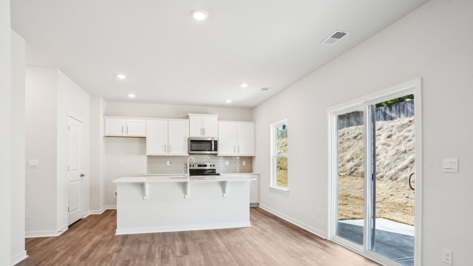 Kitchen and island with subway tile backsplash and stainless steel appliances