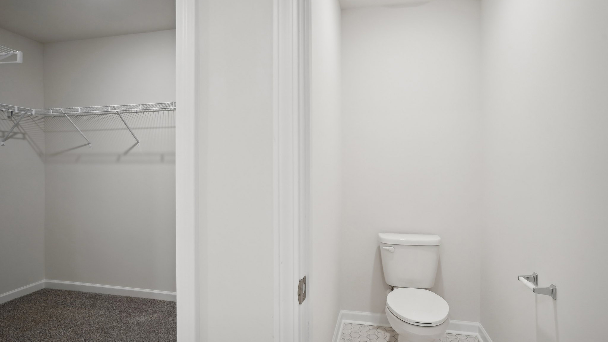 Bathroom with double sink vanity, standing glass door shower and connected walk in closet