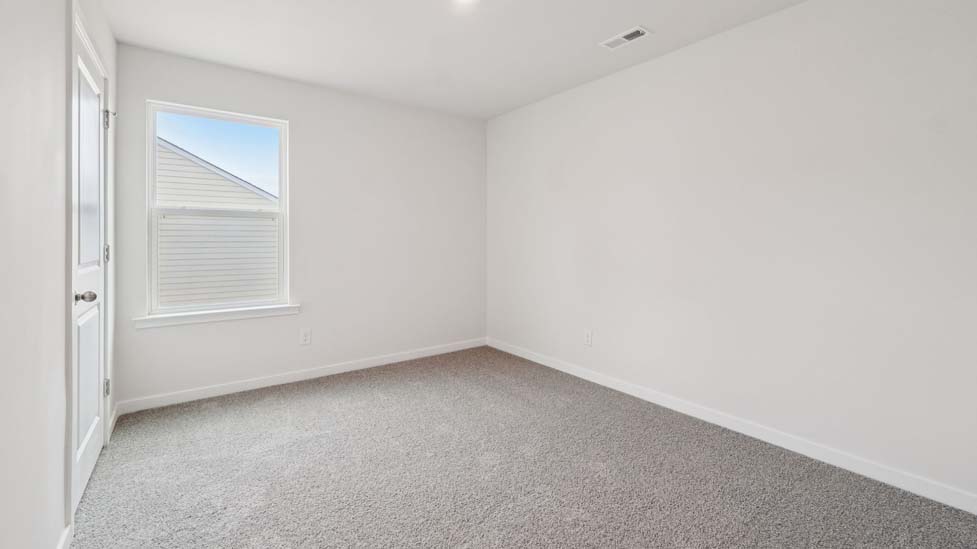 Carpeted bedroom with large window