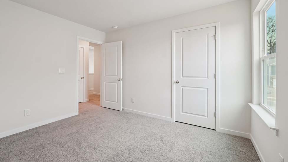 Carpeted bedroom with large window