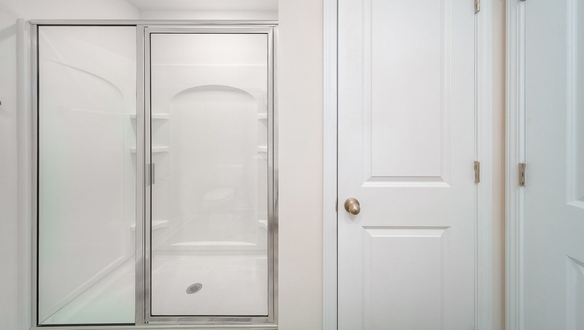 Primary bathroom with double sinks, white counters and cabinets