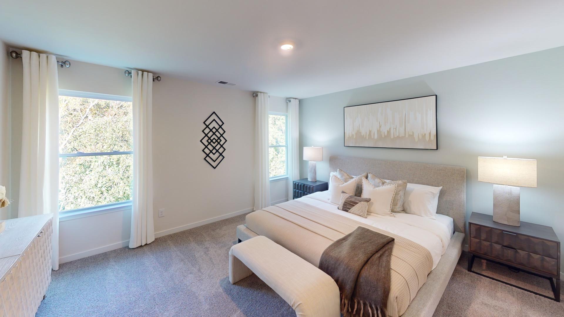 Primary bedroom with carpet and large windows