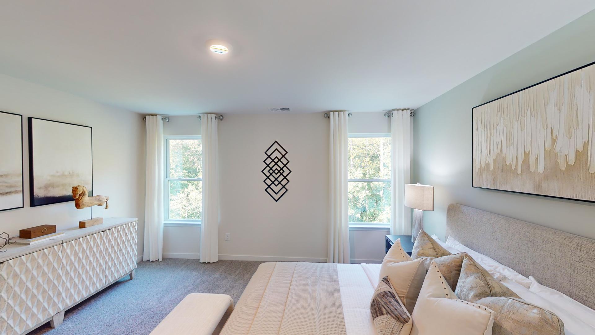Primary bedroom with carpet and large windows