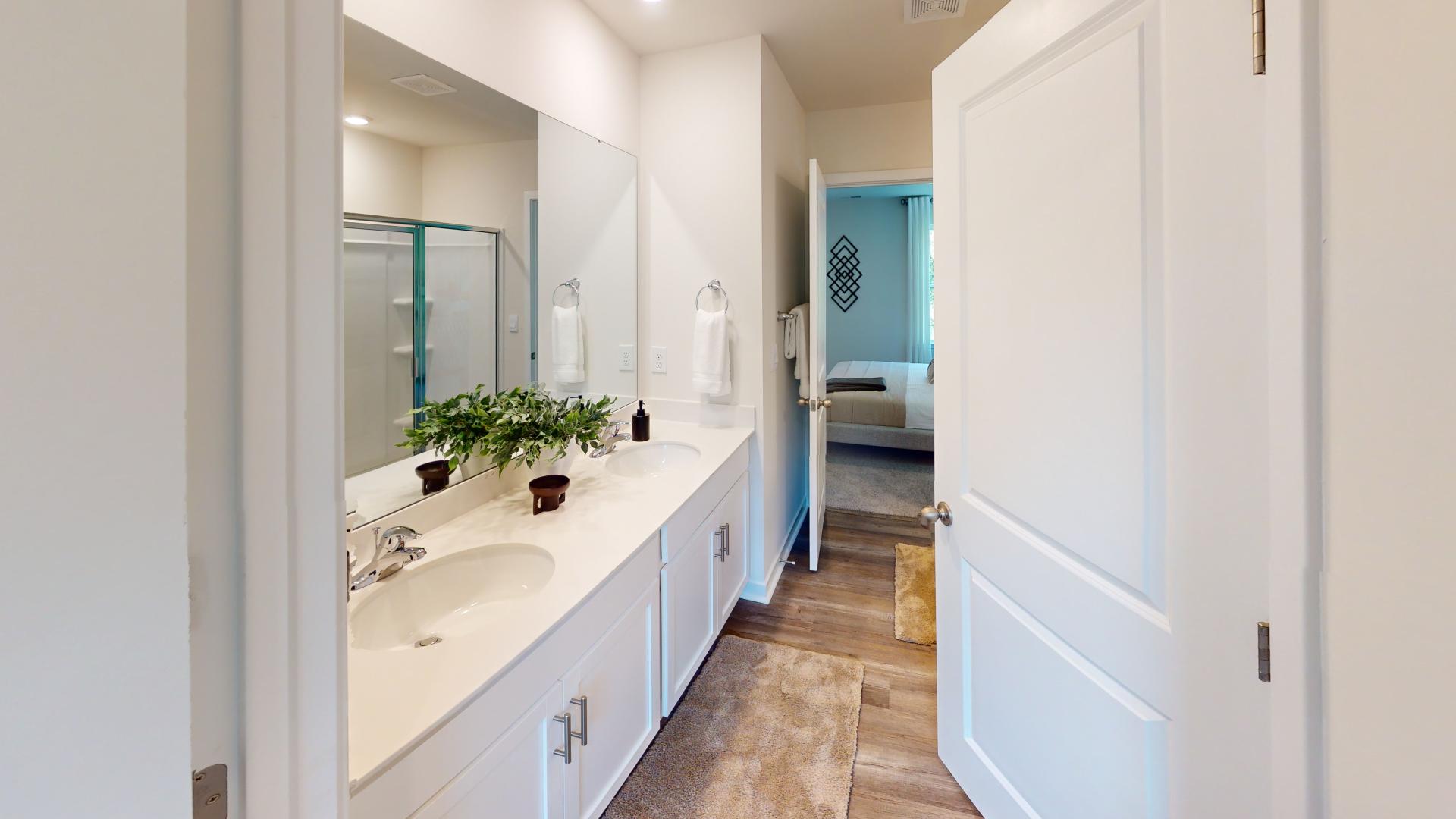 Primary bathroom with double sink vanity, and large standing glass door shower