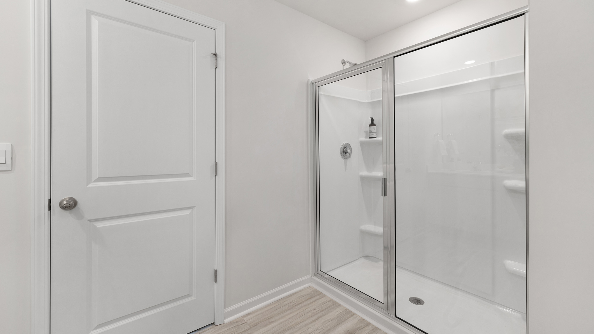 Primary bathroom with double sinks, white cabinets and counters