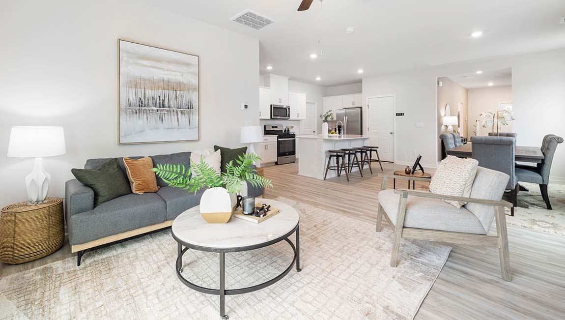 Living room area beside kitchen and dining with fireplace, ceiling fan, and sliding glass back doors