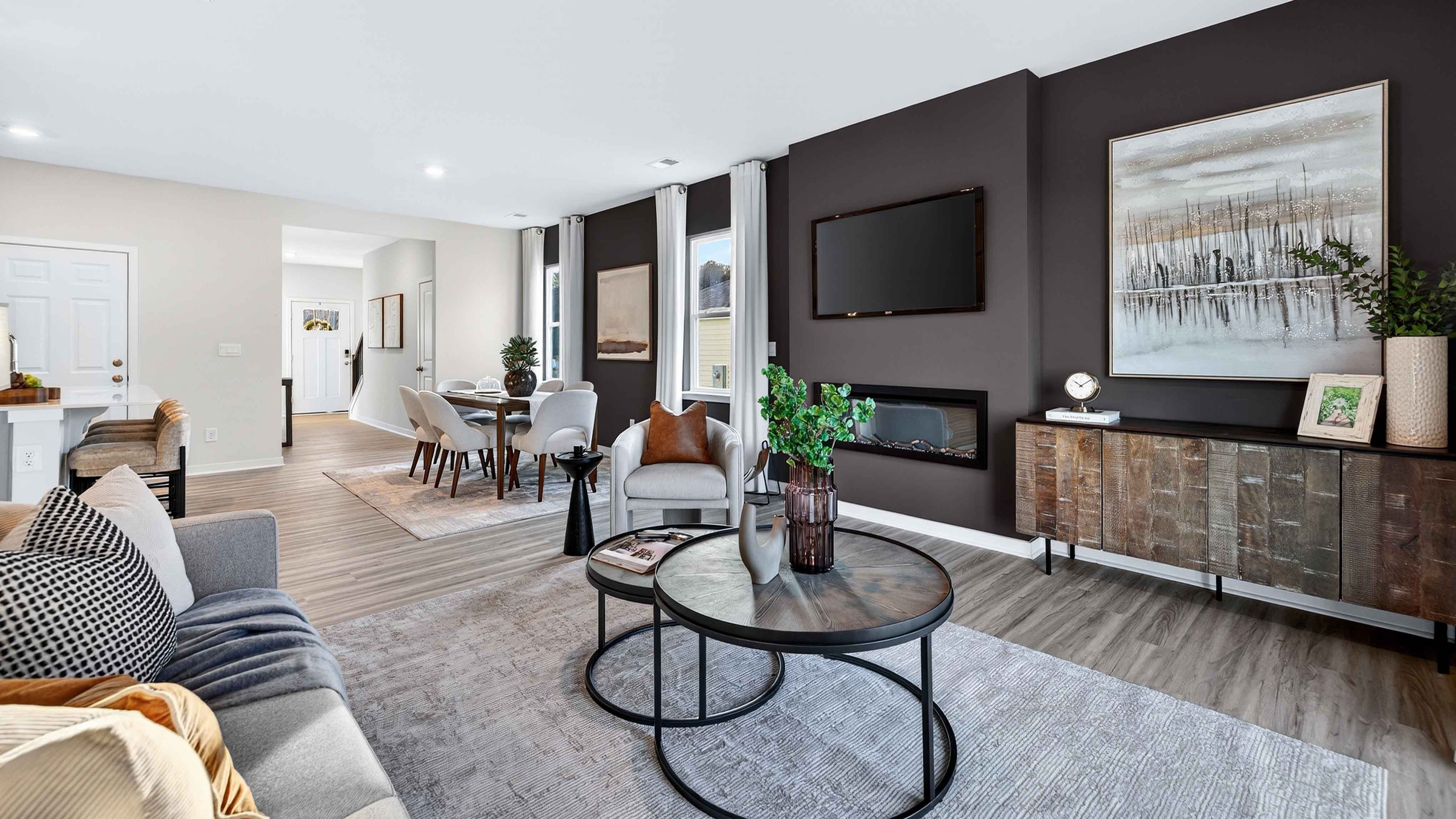 Living room area beside kitchen and dining with fireplace, ceiling fan, and sliding glass back doors