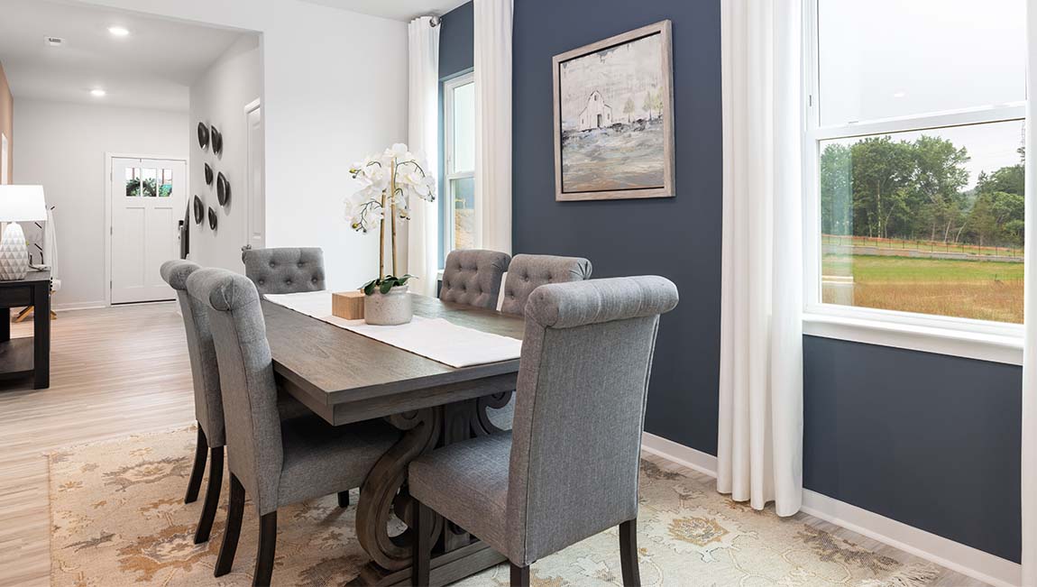 Dining area beside kitchen with large windows