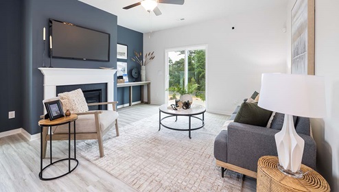 Living room area beside kitchen and dining with fireplace, ceiling fan, and sliding glass back doors
